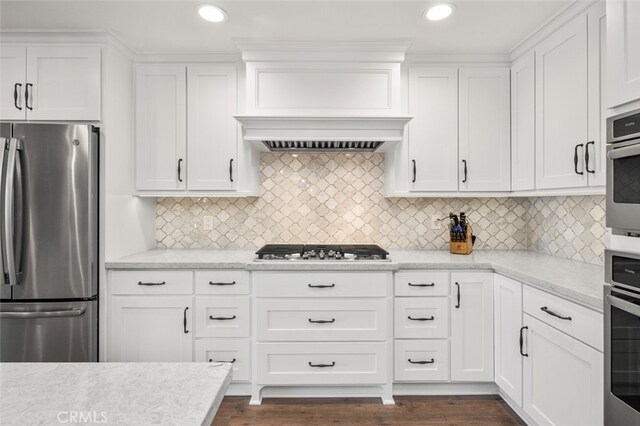21891 Winnebago Ln, Lake Forest, CA 92630 - kitchen featuring appliances with stainless steel finishes, white cabinets, dark wood finished floors, decorative backsplash, and recessed lighting