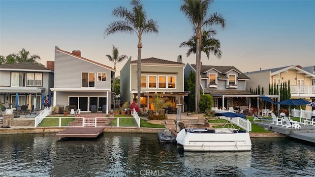21891 Winnebago Ln, Lake Forest, CA 92630 - back of house at dusk with a patio area, a water view, a fenced backyard, and a residential view