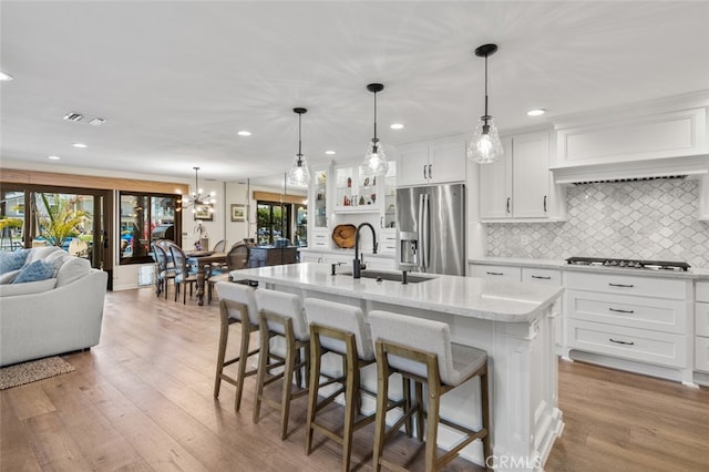 21891 Winnebago Ln, Lake Forest, CA 92630 - kitchen featuring stainless steel refrigerator with ice dispenser, stovetop, white cabinets, decorative backsplash, and recessed lighting