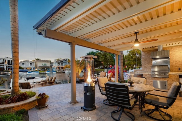 21891 Winnebago Ln, Lake Forest, CA 92630 - view of patio / terrace featuring exterior kitchen, a fire pit, a ceiling fan, and a water view