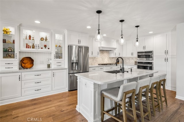 21891 Winnebago Ln, Lake Forest, CA 92630 - kitchen featuring stainless steel fridge, white cabinets, light wood-type flooring, a breakfast bar, and decorative backsplash