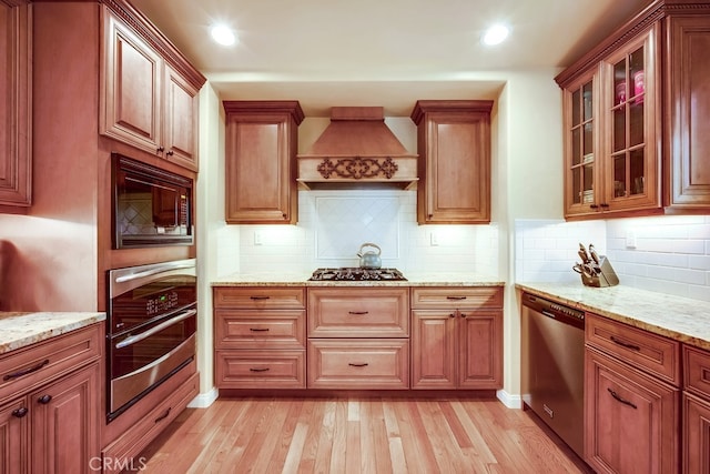 163 Wylerhorn Dr, Crestline, CA 92325 - kitchen with stainless steel appliances, custom exhaust hood, light wood-type flooring, light stone counters, and glass insert cabinets