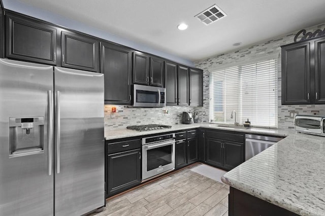 2128 Cantata # 38, Chula Vista, CA 91914 - kitchen with stainless steel appliances, dark cabinets, tasteful backsplash, and recessed lighting