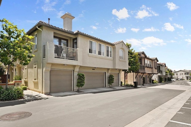 2128 Cantata # 38, Chula Vista, CA 91914 - view of front of home featuring a residential view, a chimney, a garage, stucco siding, and a tiled roof
