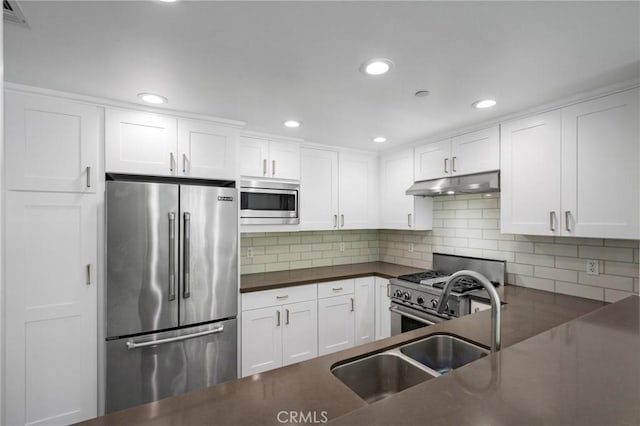 2010 S Beverly Glen Blvd Unit 103, Los Angeles, CA 90025 - kitchen featuring high end appliances, under cabinet range hood, dark countertops, white cabinets, and recessed lighting