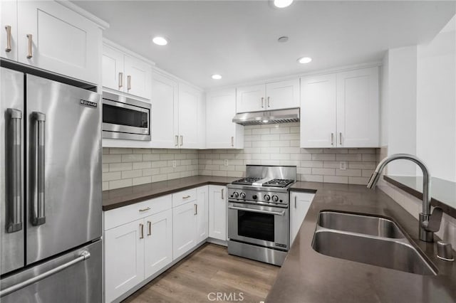 2010 S Beverly Glen Blvd Unit 103, Los Angeles, CA 90025 - kitchen with premium appliances, under cabinet range hood, dark countertops, white cabinetry, and recessed lighting