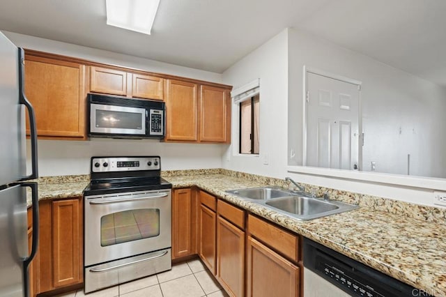 12191 Cuyamaca College Dr E Unit 213, El Cajon, CA 92019 - kitchen featuring appliances with stainless steel finishes, light tile patterned floors, brown cabinetry, and light stone counters