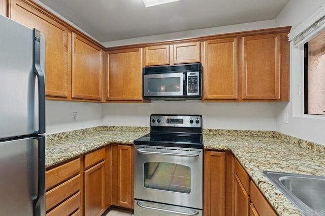 12191 Cuyamaca College Dr E Unit 213, El Cajon, CA 92019 - kitchen with stainless steel appliances, brown cabinetry, and light stone counters