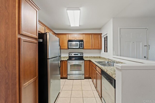 12191 Cuyamaca College Dr E Unit 213, El Cajon, CA 92019 - kitchen featuring stainless steel appliances, light tile patterned flooring, a peninsula, and brown cabinets