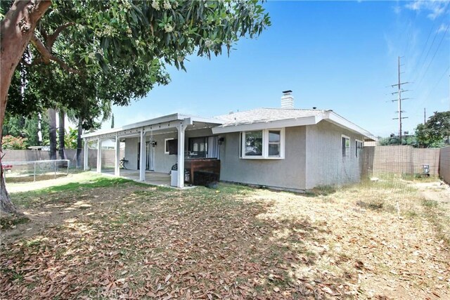 1964 Baseline Rd, La Verne, CA 91750 - back of house featuring a trampoline, a chimney, a fenced backyard, and a patio area
