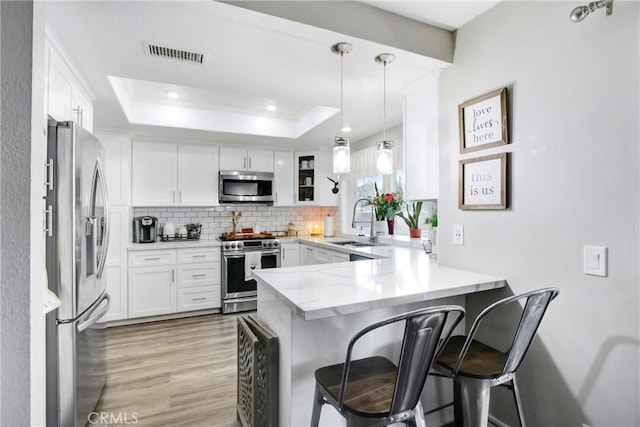 1964 Baseline Rd, La Verne, CA 91750 - kitchen featuring appliances with stainless steel finishes, a peninsula, light wood finished floors, backsplash, and white cabinets