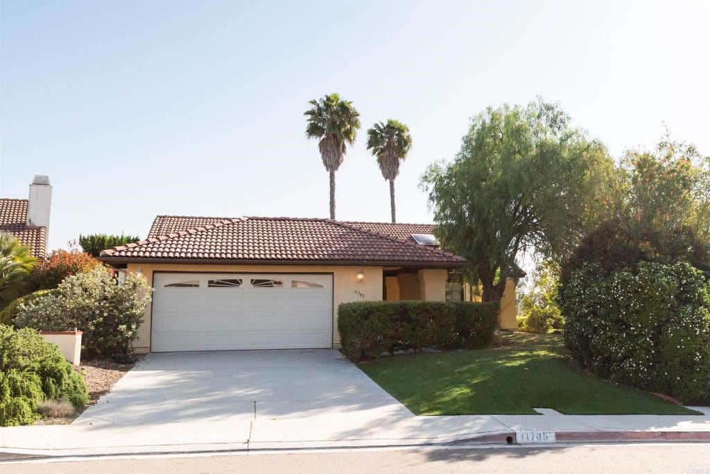 11705 Via Medanos, San Diego, CA 92128 - view of front of house with an attached garage, concrete driveway, stucco siding, a tiled roof, and a front yard