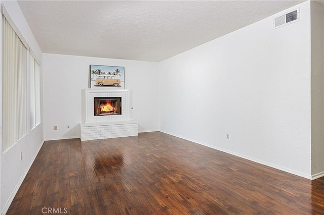 25644 Mont Pointe Unit 1A, Lake Forest, CA 92630 - unfurnished living room featuring a fireplace, dark wood-type flooring, and a textured ceiling