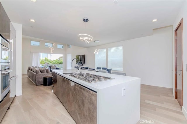 615 El Redondo Ave, Redondo Beach, CA 90277 - kitchen featuring modern cabinets, stainless steel gas cooktop, light wood finished floors, light countertops, and a kitchen island with sink