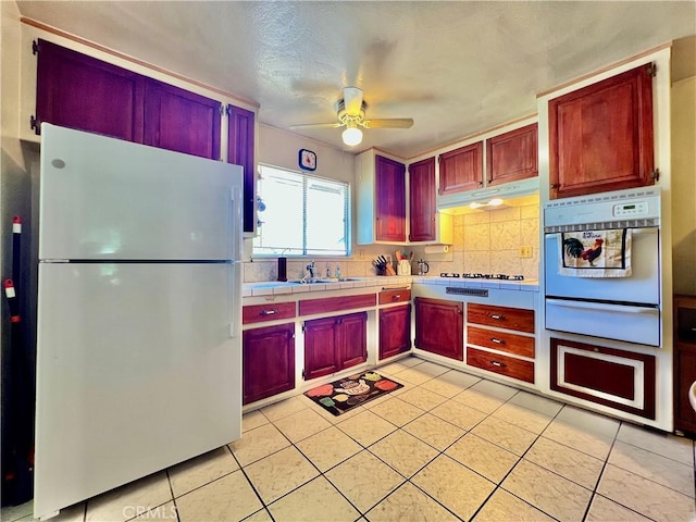 8675 Colorado Ave, Riverside, CA 92504 - kitchen featuring white appliances, a warming drawer, under cabinet range hood, a ceiling fan, and light tile patterned floors