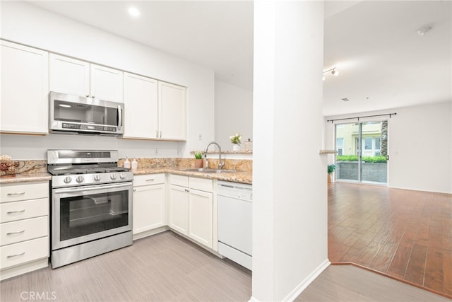 6400 Crescent E Unit 121, Playa Vista, CA 90094 - kitchen featuring stainless steel appliances, white cabinets, light wood-type flooring, and light stone countertops
