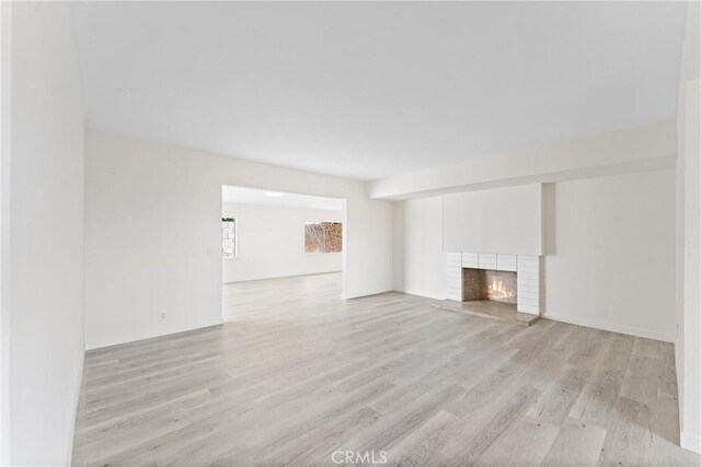558 W Philadelphia St, Ontario, CA 91762 - unfurnished living room with light wood-style flooring and a brick fireplace