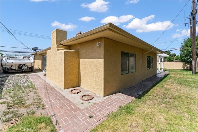 558 W Philadelphia St, Ontario, CA 91762 - view of home's exterior featuring stucco siding and a lawn
