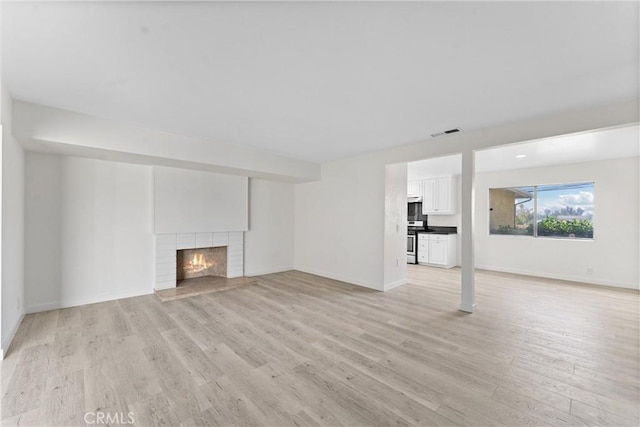558 W Philadelphia St, Ontario, CA 91762 - unfurnished living room with light wood-style flooring and a brick fireplace