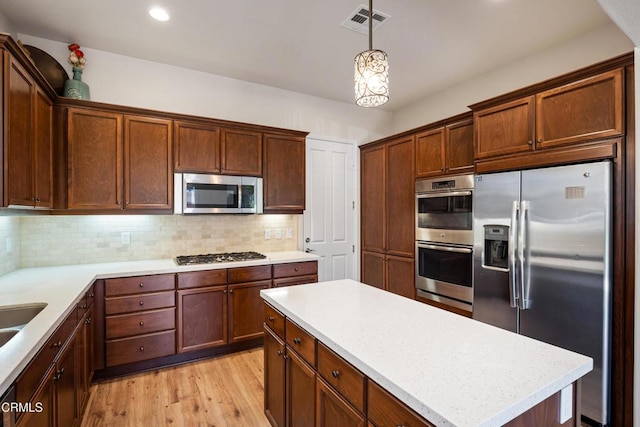 1655 Range Rd, Oxnard, CA 93036 - kitchen with appliances with stainless steel finishes, backsplash, light wood-style flooring, hanging light fixtures, and recessed lighting