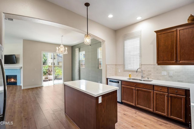 1655 Range Rd, Oxnard, CA 93036 - kitchen with dishwasher, light countertops, light wood-style flooring, a kitchen island, and decorative backsplash