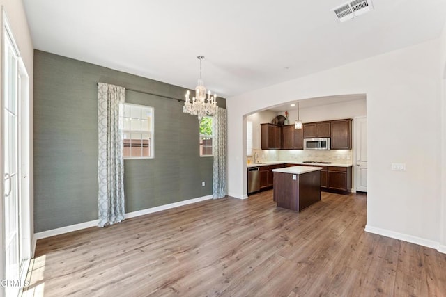 1655 Range Rd, Oxnard, CA 93036 - kitchen featuring appliances with stainless steel finishes, a chandelier, a kitchen island, light countertops, and wood finished floors