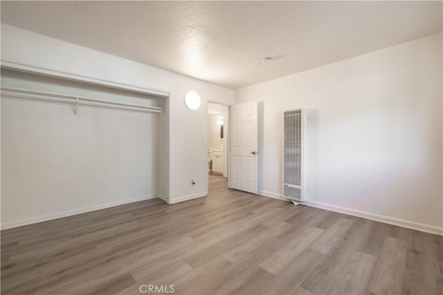 1044 E Country Club Blvd, Big Bear City, CA 92314 - unfurnished bedroom with a heating unit, wood finished floors, a closet, and a textured ceiling