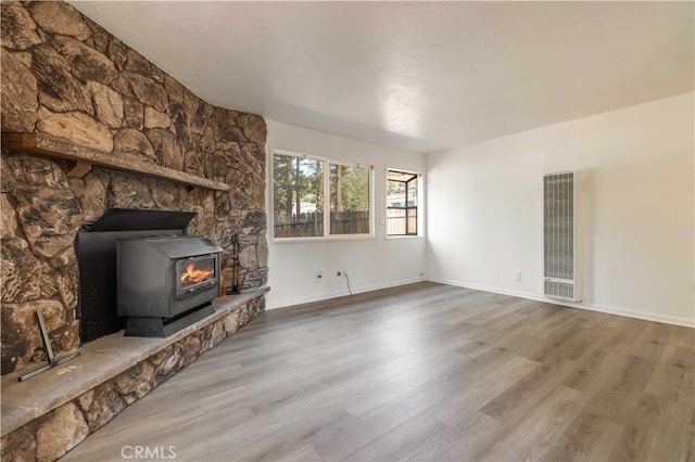1044 E Country Club Blvd, Big Bear City, CA 92314 - unfurnished living room with a heating unit, a wood stove, and wood finished floors