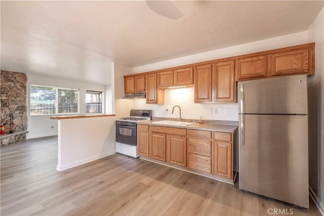 1044 E Country Club Blvd, Big Bear City, CA 92314 - kitchen featuring freestanding refrigerator, white range with gas stovetop, under cabinet range hood, light countertops, and light wood finished floors