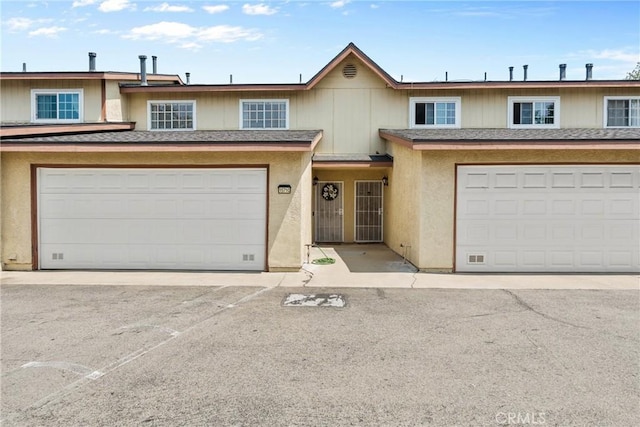 1571 S Reservoir St Unit C, Pomona, CA 91766 - view of property with a shingled roof, a garage, and stucco siding