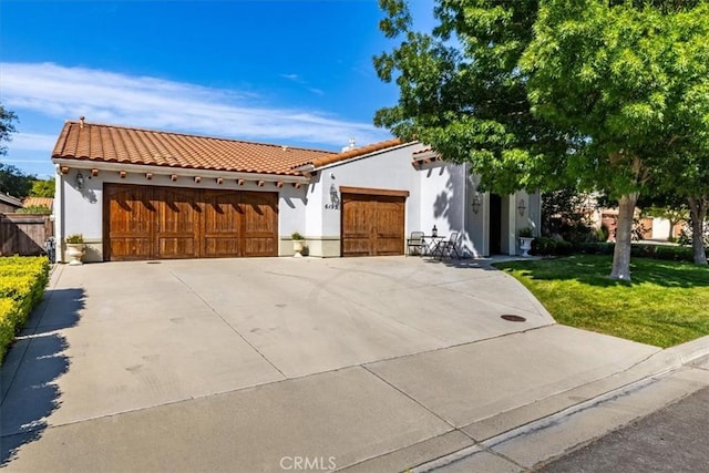 6195 Via Huerto Ct, Atascadero, CA 93422 - mediterranean / spanish-style home with stucco siding, a garage, a tile roof, and a front lawn