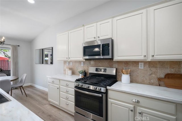 2636 Vineyard Cir, Paso Robles, CA 93446 - kitchen featuring stainless steel appliances, lofted ceiling, tasteful backsplash, light wood-type flooring, and a chandelier