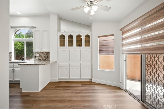477 S Maidstone St, Banning, CA 92220 - kitchen featuring white cabinetry, a peninsula, vaulted ceiling, a ceiling fan, and light stone countertops