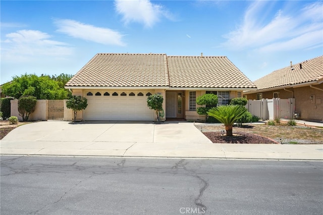 477 S Maidstone St, Banning, CA 92220 - view of front of home with a tiled roof, a garage, concrete driveway, stucco siding, and a gate