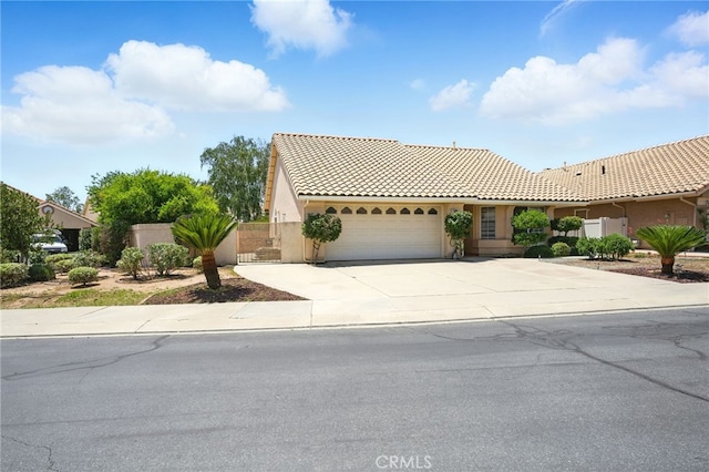 477 S Maidstone St, Banning, CA 92220 - view of front of house with a garage, a tiled roof, concrete driveway, and stucco siding