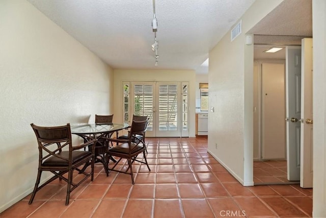 2829 Irving St, Riverside, CA 92504 - dining space featuring track lighting, tile patterned flooring, a textured ceiling, and a textured wall