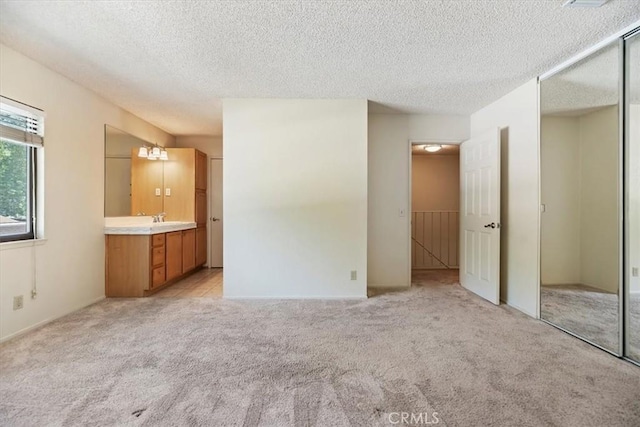 2829 Irving St, Riverside, CA 92504 - unfurnished bedroom featuring light carpet, a closet, a textured ceiling, and ensuite bathroom