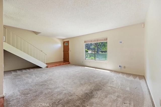 2829 Irving St, Riverside, CA 92504 - unfurnished living room featuring a textured ceiling, carpet, and stairway