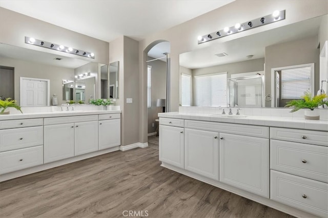 420 Deodar St, Redlands, CA 92374 - bathroom with wood finished floors, a stall shower, and two vanities