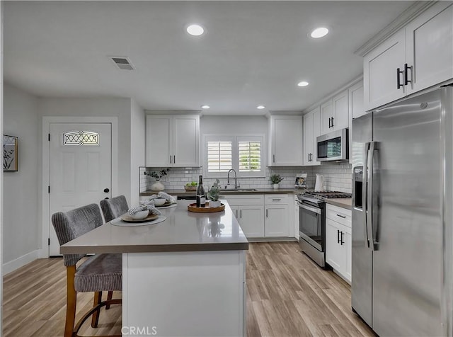 2867 Turnbull St, Oceanside, CA 92054 - kitchen with appliances with stainless steel finishes, a breakfast bar area, backsplash, light wood-style flooring, and recessed lighting