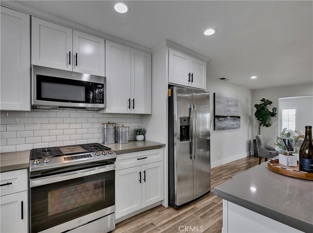 2867 Turnbull St, Oceanside, CA 92054 - kitchen with stainless steel appliances, light wood-style floors, recessed lighting, dark countertops, and tasteful backsplash