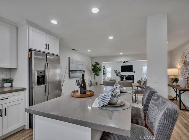 2867 Turnbull St, Oceanside, CA 92054 - kitchen with stainless steel fridge with ice dispenser, light wood-type flooring, white cabinets, recessed lighting, and open floor plan
