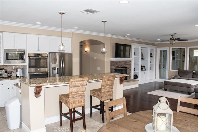 1671 Fairway Dr, Corona, CA 92883 - kitchen featuring appliances with stainless steel finishes, arched walkways, ceiling fan, open floor plan, and ornamental molding