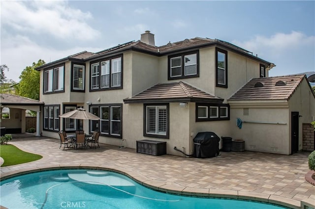 1671 Fairway Dr, Corona, CA 92883 - rear view of property featuring a patio, an outdoor pool, stucco siding, a chimney, and a tile roof