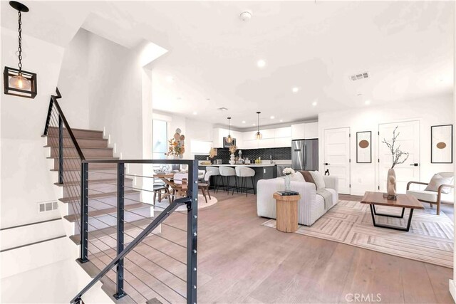 1131/2 N Manhattan Pl, Los Angeles, CA 90004 - living room featuring light wood-type flooring, recessed lighting, and stairs