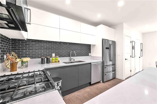 1131/2 N Manhattan Pl, Los Angeles, CA 90004 - kitchen featuring appliances with stainless steel finishes, light wood-style flooring, light countertops, tasteful backsplash, and white cabinetry