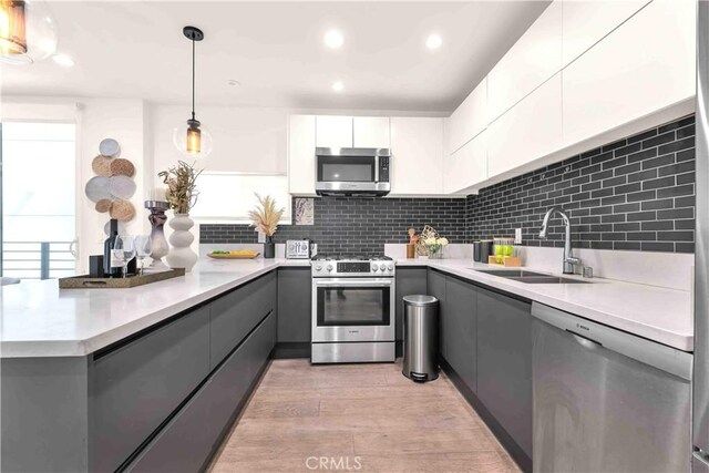 1131/2 N Manhattan Pl, Los Angeles, CA 90004 - kitchen featuring appliances with stainless steel finishes, gray cabinets, modern cabinets, and recessed lighting