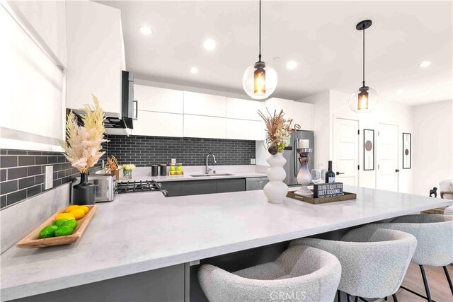 1131/2 N Manhattan Pl, Los Angeles, CA 90004 - kitchen featuring a kitchen bar, modern cabinets, decorative backsplash, decorative light fixtures, and recessed lighting