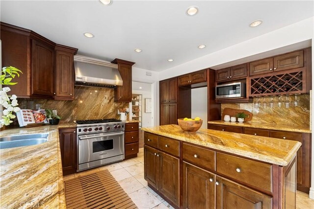 9767 Blantyre Dr, Beverly Hills, CA 90210 - kitchen featuring stainless steel appliances, wall chimney range hood, tasteful backsplash, light stone countertops, and recessed lighting