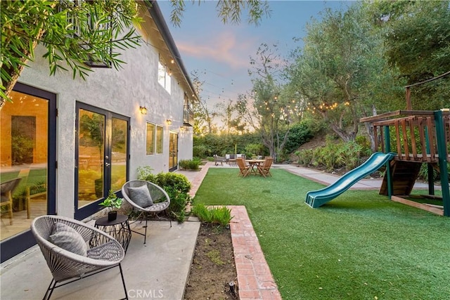 9767 Blantyre Dr, Beverly Hills, CA 90210 - yard at dusk featuring a playground, a lawn, and a patio